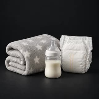 Baby and household supplies laid out for an emergency kit, including nappies and a comfort item